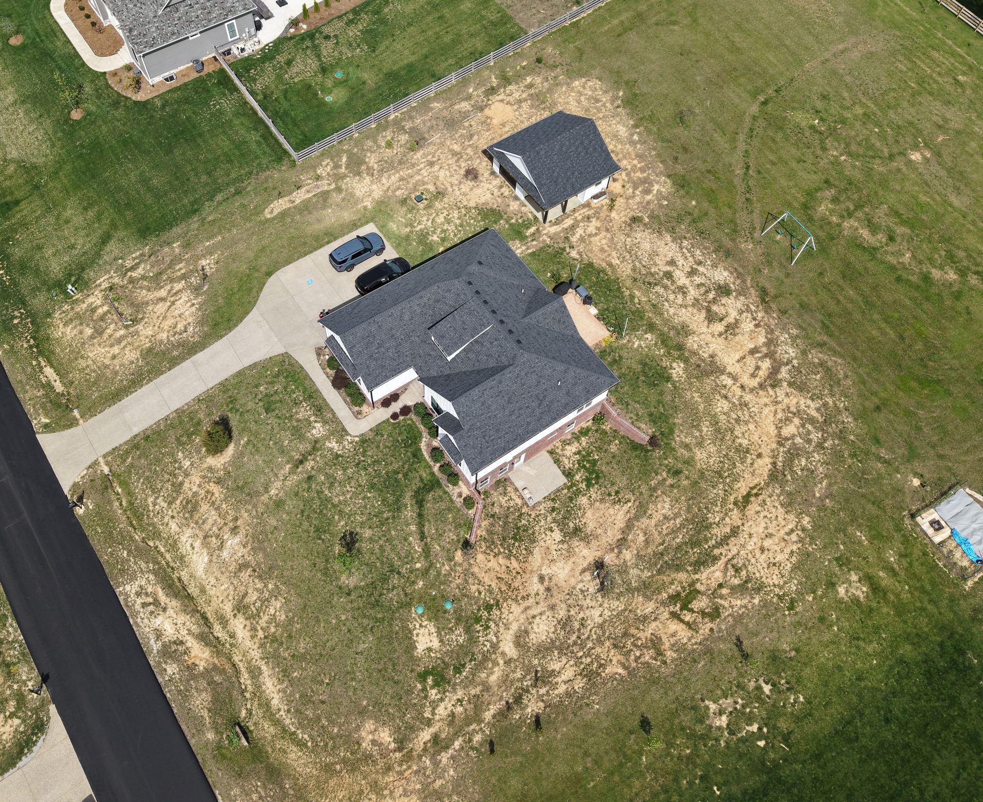 Aerial view of a Louisville-area property showing the roof, driveway, detached garage, and surrounding land